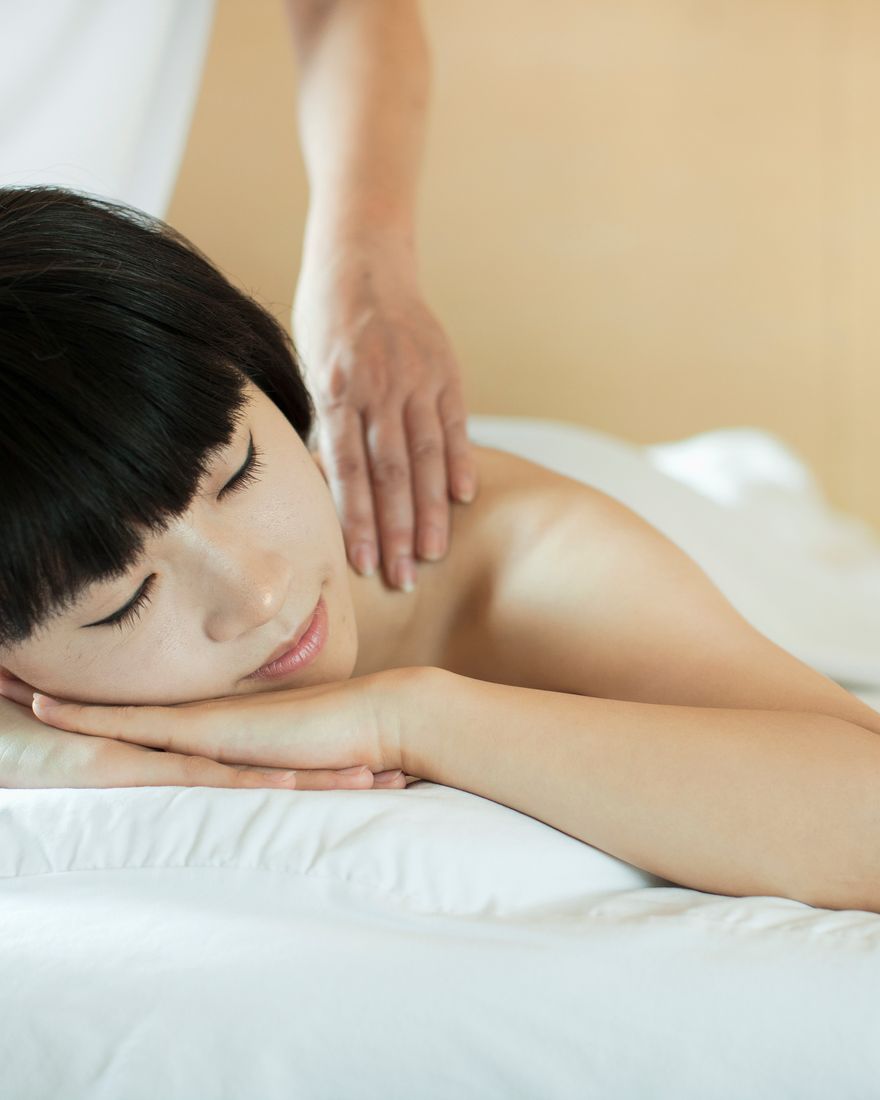顧客趴臥放鬆，師傅按摩背部